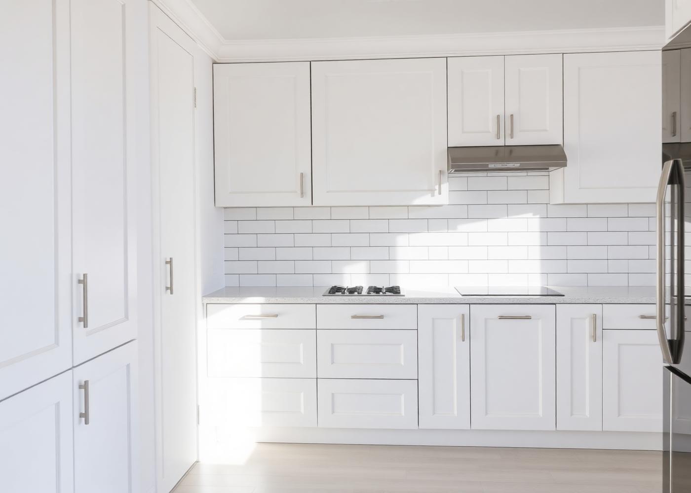 Recently repainted kitchen with clean cabinets and backsplash